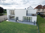 Ansicht Rückseite Haus - Zentrale Neubauwohnung mit Terrasse – 2 Zimmer, modern & hell